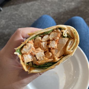 Maple Leaf Lounge - a hand holding a chicken salad wrap - Airport Lounges Near Me - Mississauga, Ontario