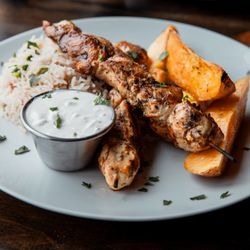 Nisi Greek Taverna - Juicy Chicken Souvlaki with roasted potatoes, seasoned rice and home-made tzatziki sauce!