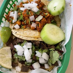 El pastor taco (top) and Asada taco (bottom) with onions and cilantro El pastor taco (top) and Asada taco (bottom) with onions and cilantro