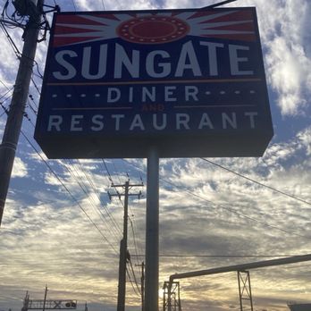 Sungate Diner - Sign! - A rectangular sign for Sungate Diner and Restaurant is attached to a pole outdoors, with a cloudy sky and utility poles in the background. - Diners Near Me - Marcus Hook, Pennsylvania