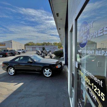 Dent Express - R129 SL500 and Eric's OBS SVT Lightning, oh yea! Eric has good taste in cars & trucks too. - A black coupe is parked outside Dent Express, a paintless dent repair shop, with a glass window reflecting the sky and nearby buildings. - Mobile Dent Repair Near Me - Vacaville, California