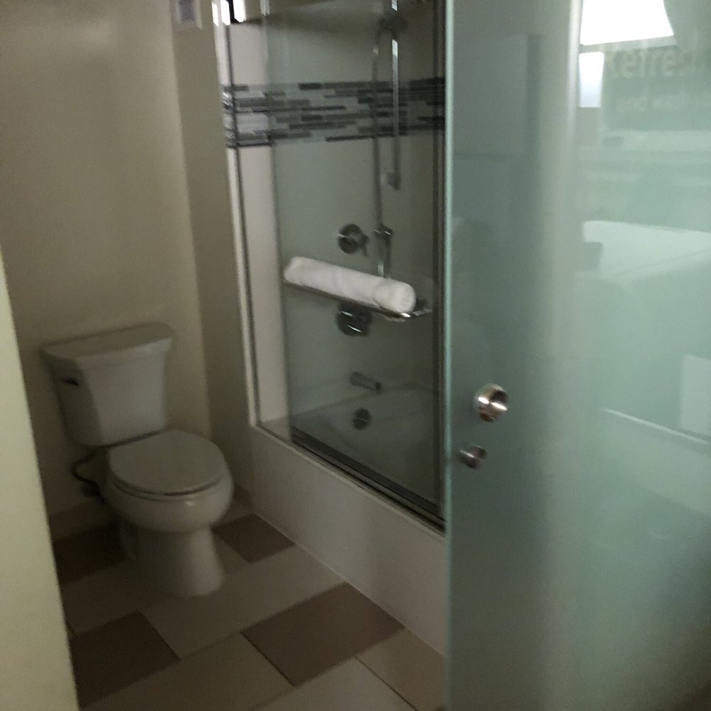 EVEN Hotel Norwalk - Bathroom. Glass enclosed shower. Frosted glass barn door. - Hotels Near Me - Norwalk, Connecticut