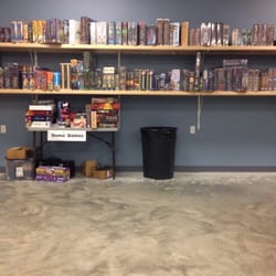 Gamers Paradise - Shelves have a large assortment of games available for purchase. Table has open copies of games to try and play.