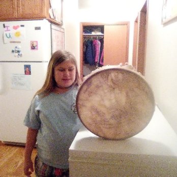 Aurora Tours - Aurora, the company namesake, holding a drum that her mom made. - Bus Tours Near Me