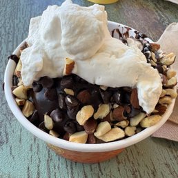 Hot fudge sundae with chocolate macadamia nut ice cream, single scoop topped with toasted almonds