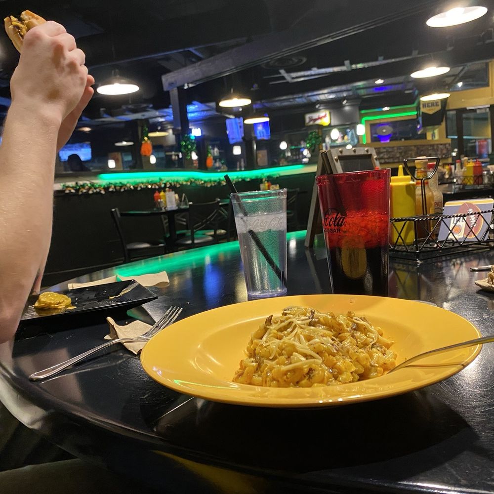 Mac Daddy’s - a woman eating pasta at a restaurant - American Near Me - Spokane, Washington