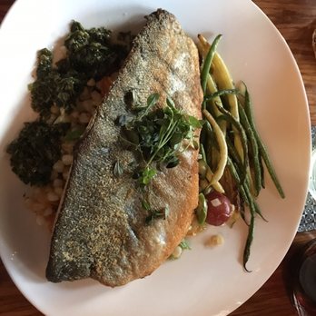 Citronnelle - Fish du jour. Every aspect of this entree was amazing! - A dish with a whole fried fish, garnished with fresh herbs, is presented on a white plate. Accompanying the fish are green beans, cherry tomatoes, and a grain mixture, with leafy greens on the side. The presentation emphasizes the fish as the main feature, with colorful vegetables and grains providing complementary elements. - French Near Me - Lancaster, Pennsylvania