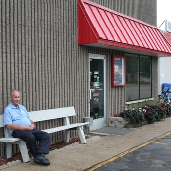 Wonderland Tire - Owner Chet Reed sits proudly in front of Reed's Tire. At 75, Chet stills works everyday. - Tires Near Me - Holland, Michigan Wonderland Tire - Owner Chet Reed sits proudly in front of Reed's Tire. At 75, Chet stills works everyday. - Tires Near Me - Holland, Michigan