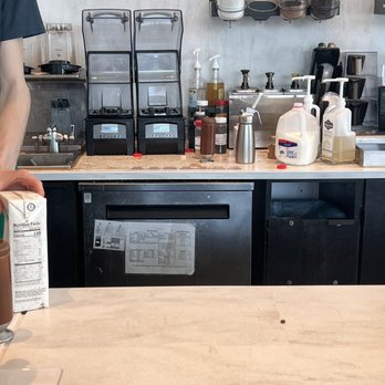 Starbucks - a man holding a carton of coffee in a kitchen - Coffee & Tea Near Me - Clearlake, California