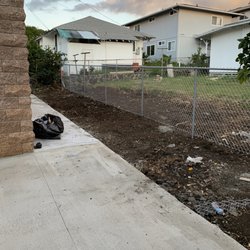Elite Masons - AFTER - the end result after removing all the trees and pouring a new sidewalk. The entire fencing area used to be covered with tall trees.