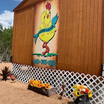 Chicken Liquor - a wooden building with a sign and flowers - Beverage Store Near Me - Briggs, Texas Chicken Liquor - a wooden building with a sign and flowers - Beverage Store Near Me - Briggs, Texas