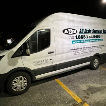 All Drain Services - A white All Drain Services, Inc. van is parked in a lot at night, displaying company branding, contact number, website, and service details. - Plumbing Near Me