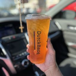 a hand holding a cup of iced coffee a hand holding a cup of iced coffee