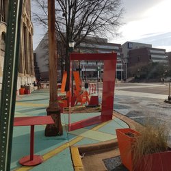 Blue Zones - A public space with chairs, tables, a pay phone, and SWINGS!