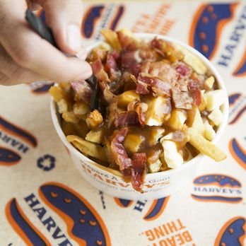 Harvey's - a person eating a bowl of french fries - Fast Food Near Me - Wasaga Beach, Ontario Harvey's - a person eating a bowl of french fries - Fast Food Near Me - Wasaga Beach, Ontario