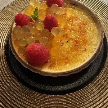 Cataluna - Crème brûlée, different twist I think it needed more hard sugar on top, and maybe a fruity purée instead of the poppy balls - Mediterranean Near Me - Jacksonville, Florida