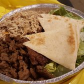 Photo of The Halal Guys - Costa Mesa, CA, United States. Halal Classic platter ($9.95). Gyro meat and chicken covering rice. Pita portions. Salad.
