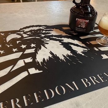 Freedom Brewing - a bottle of beer and a beer glass on a table - Breweries Near Me - Holbrook, New York