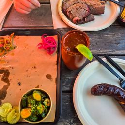 Spicy cucumbers (side), daily sausage (jalapeño and cheese), house michelada, and three pieces of brisket with a coors banquet Spicy cucumbers (side), daily sausage (jalapeño and cheese), house michelada, and three pieces of brisket with a coors banquet