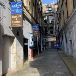 The Chippy Doon The Lane - Signage along the alley to the entrance, sideways vertical lettering with the restaurant name on the front of the building.
