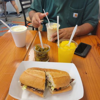 Juice N Fruit Raspados - Torta de Milanesa with a Raspado de Piña in front Coctel de Elote and cookies and crean icecream cup in back - Juice Bars & Smoothies Near Me - Tucson, Arizona