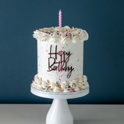Elegant Temptations - Tall, sweet, and full of fun--this Funfetti cake is frosted in vanilla buttercream, topped with sprinkles and a swirl of birthday magic!