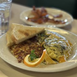 Peg's Glorified Ham N Eggs - Custom omelette made to order with hash browns, sour dough toast and a side of bacon.