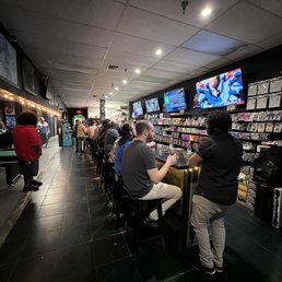 people sitting at tables in a game room people sitting at tables in a game room