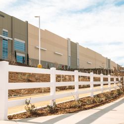 A & A Fence Company - White three-rail property fencing installed alongside a large commercial development. This project shows the range of fencing...