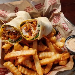Huey Magoo's Chicken Tenders - Breaded Buffalo wrap with fries, extra seasoning and a side of Magoo sauce