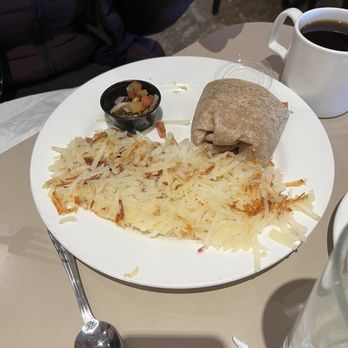 Elly's Pancake House - A breakfast plate featuring hash browns, a rolled tortilla, a small bowl of salsa, and a cup of black coffee on a table. - Breakfast & Brunch Near Me - Norridge, Illinois