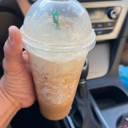 a hand holding a cup of iced coffee