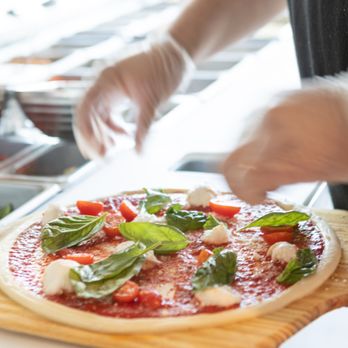 Blaze Pizza - a person preparing a pizza on a cutting board - Salad Near Me - Twin Falls, Idaho Blaze Pizza - a person preparing a pizza on a cutting board - Salad Near Me - Twin Falls, Idaho
