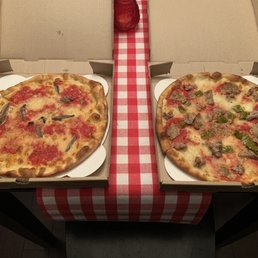 two pizzas in boxes on a table two pizzas in boxes on a table