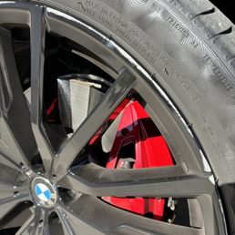 Gloss black BMW wheel with curb damage