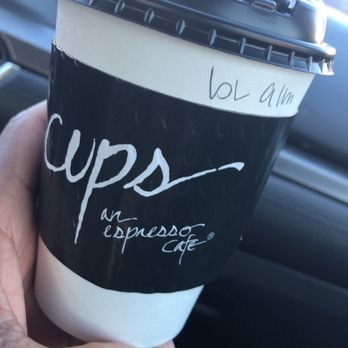Cups an  Espresso Cafe - Blondie - A person holds a coffee cup from Cups Espresso Cafe in Jackson, MS, inside a vehicle. The cup has a black sleeve with white writing and a handwritten note. - Coffee & Tea Near Me - Jackson, Mississippi