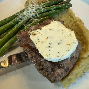 Brick + Mortar - Filet - A meal featuring a grilled steak with herb butter, served alongside cooked green asparagus and mashed potatoes. - Bars Near Me - Pittsburg, Kansas