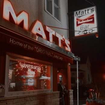Matt's Bar - a man standing in front of a restaurant - Burgers Near Me - Minneapolis, Minnesota