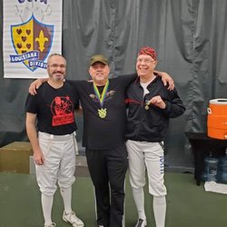 Three of our veteran fencers at a tournament in New Orleans. Our own coach is in the picture. Can you spot him?