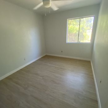 Pro Floors - a room with a ceiling fan and a window - Flooring Near Me