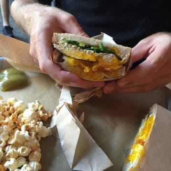 Kitchen Table - The whole chicken sandwich and the side popcorn (a little spicy- perfect!) and a pickled green pepper! - New American Near Me - Omaha, Nebraska