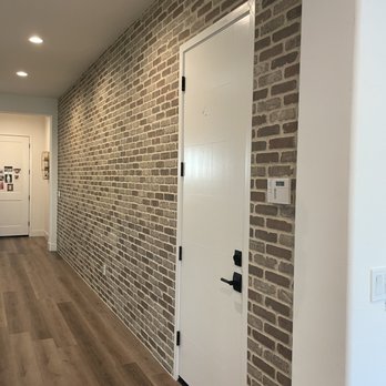 Complete Construction & Realty - a brick wall with a white door - General Contractors Near Me Complete Construction & Realty - a brick wall with a white door - General Contractors Near Me
