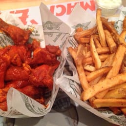 two baskets of chicken wings and french fries