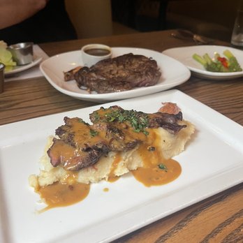 Cuts Steakhouse - Steak au poivre over top the Roasted Garlic Mashed Potatoes and behind is the Ribeye - Steakhouses Near Me - Atlanta, Georgia Cuts Steakhouse - Steak au poivre over top the Roasted Garlic Mashed Potatoes and behind is the Ribeye - Steakhouses Near Me - Atlanta, Georgia