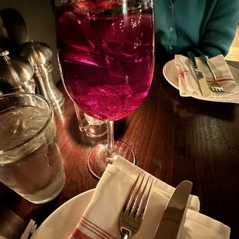 Papa Razzi- Wellesley -  a woman sitting at a table with a glass of wine - Italian Near Me - Wellesley, Massachusetts