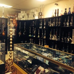 Vaporizer case with water pipes and hookahs in the background.