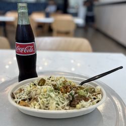 DosBros - Chicken and carnitas bowl with cilantro and lime white rice topped with guacamole, jalapeños, and cheese.