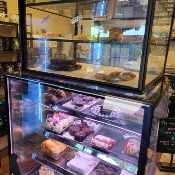 Blackbird Coffee House - Desserts and pastries - A multi-tiered glass display case showcases an assortment of baked goods, including cakes, cookies, and pastries, in a cafe or bakery setting. - Coffee & Tea Near Me - Albuquerque, New Mexico