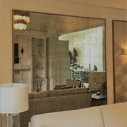Glass and More - Mirrors can add dimension to your living space. This mirrored tile application also adds a decorative touch to this room.