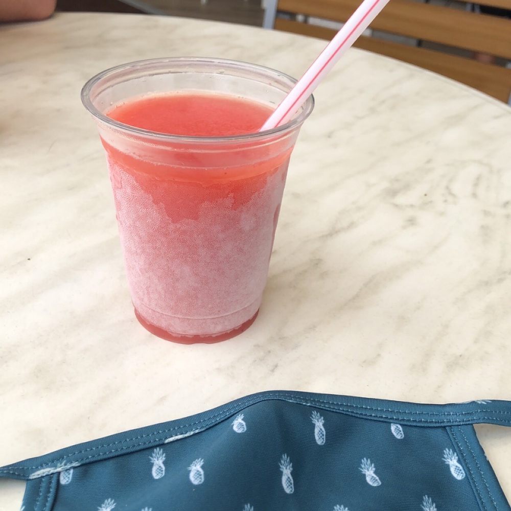 a drink and a mask on a table a drink and a mask on a table